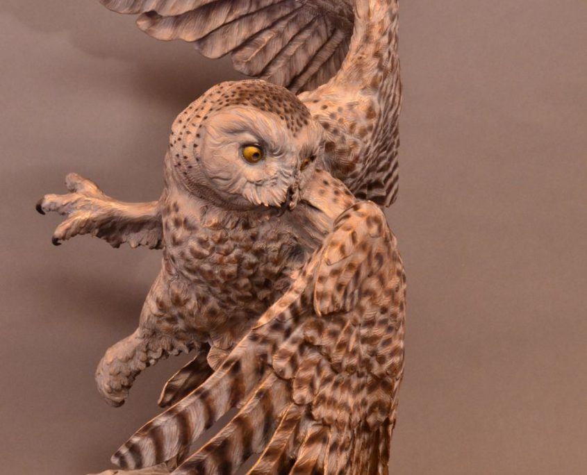 A bronze sculpture by Jim Green of a female Snowy Owl in flight.